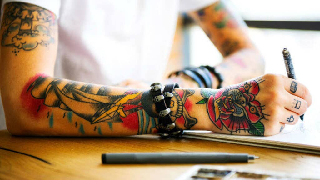 Close up image of a person with coloured arm tattoos.