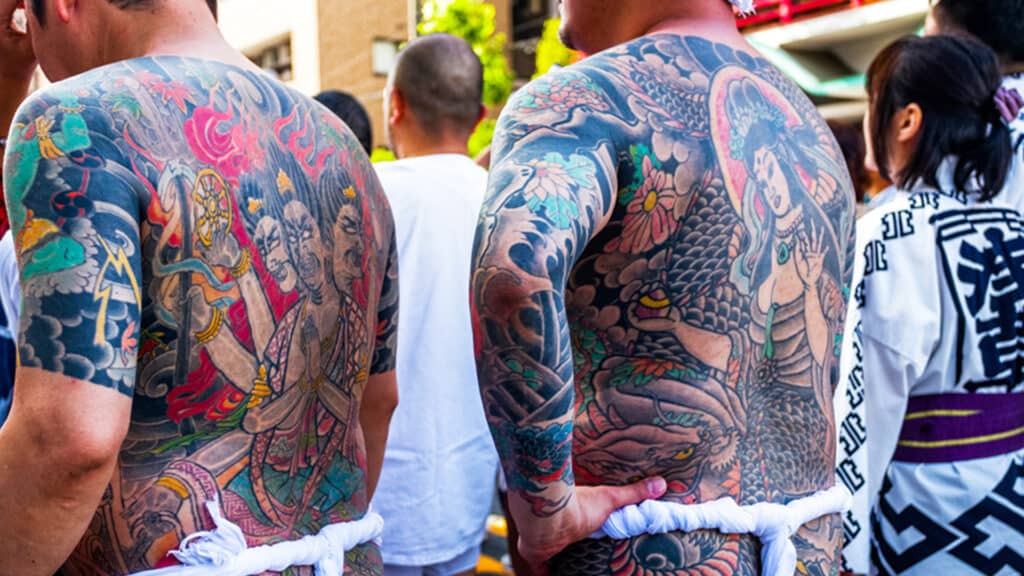 Image of two people with coloured body tattoos.