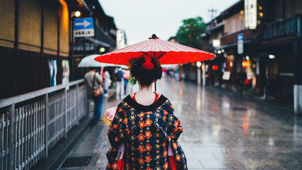 Geisha walking with an japanese traditional umbrella