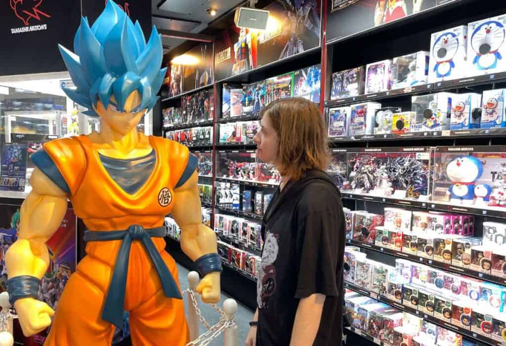 Tokyo-Akihabara-girl looking at large son goku statue-landscape-1 (Exploring Akihabara: Living the Ultimate Otaku Dream)