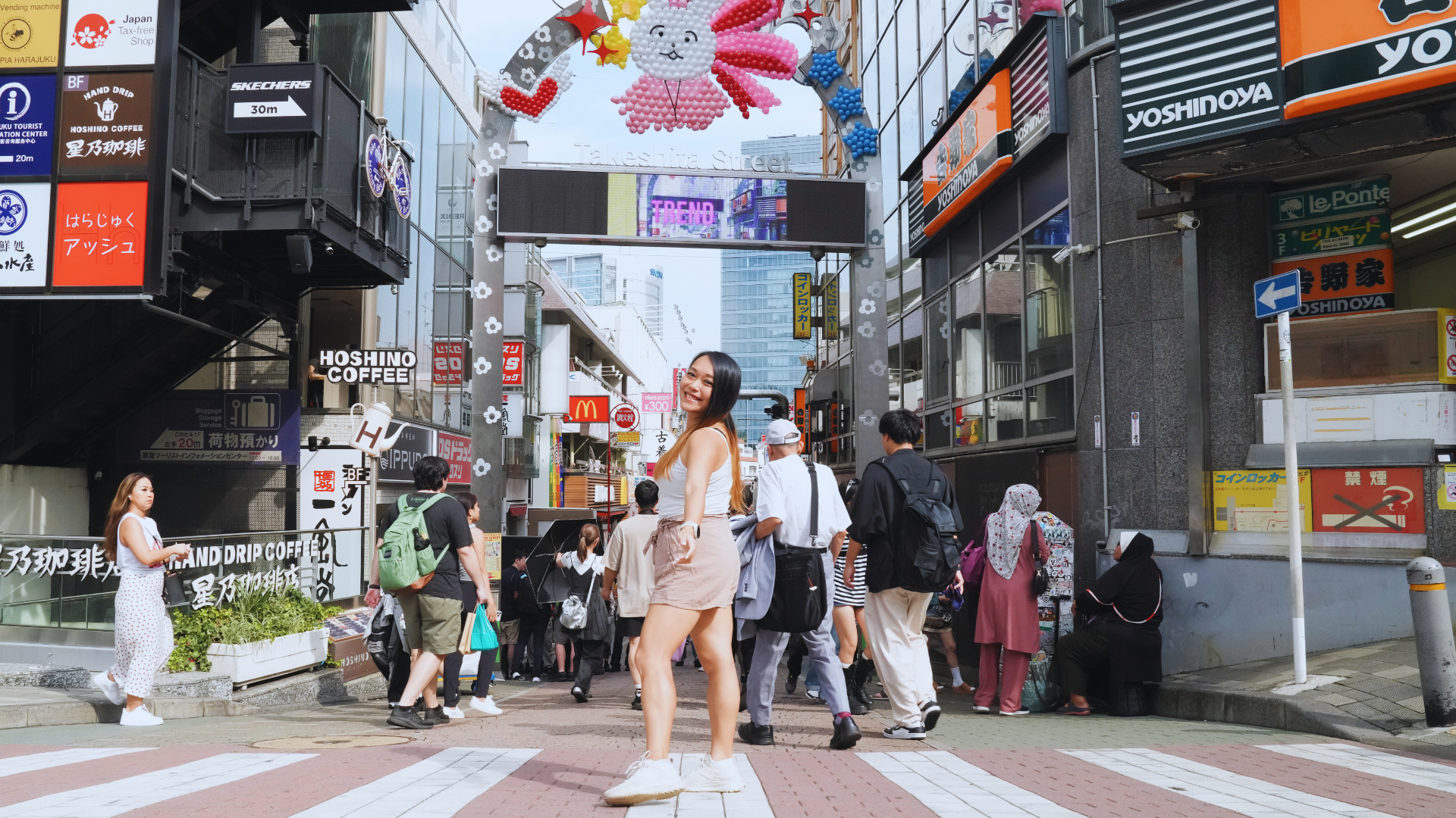 Flip Japan photo of a woman standing at the entrance to takeshita street for unique things to do in Japan
