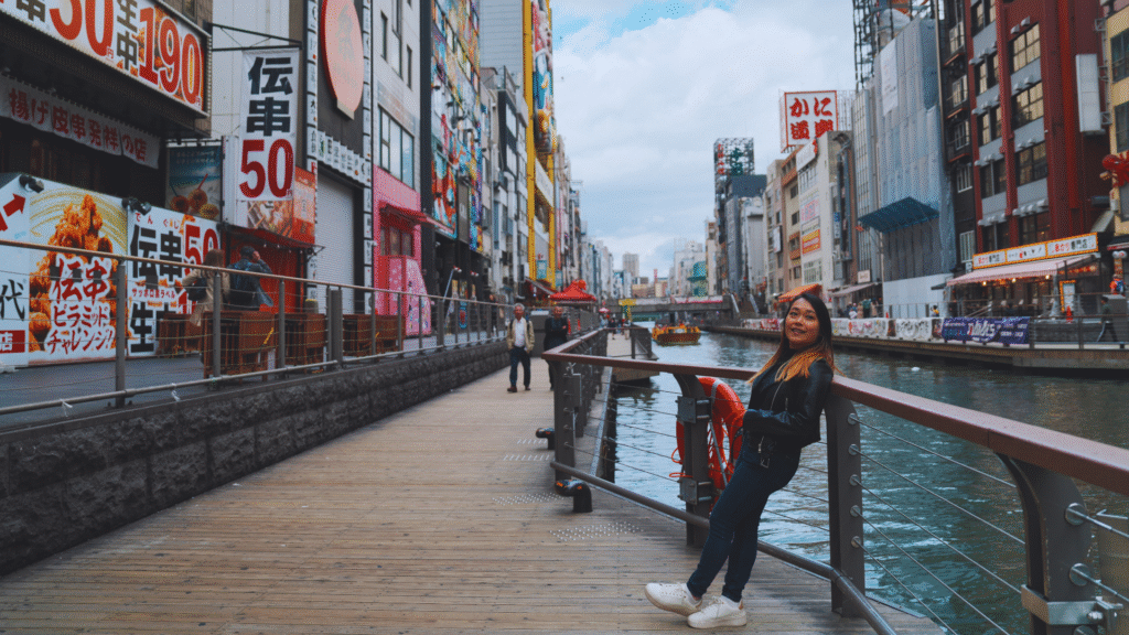 Flip Japan photo of a woman standing against the river in Namba, Osaka vs Tokyo