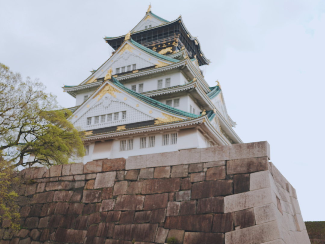 Flip Japan photo of a woman in front of Osaka castle for Osaka vs Tokyo vs Kyoto