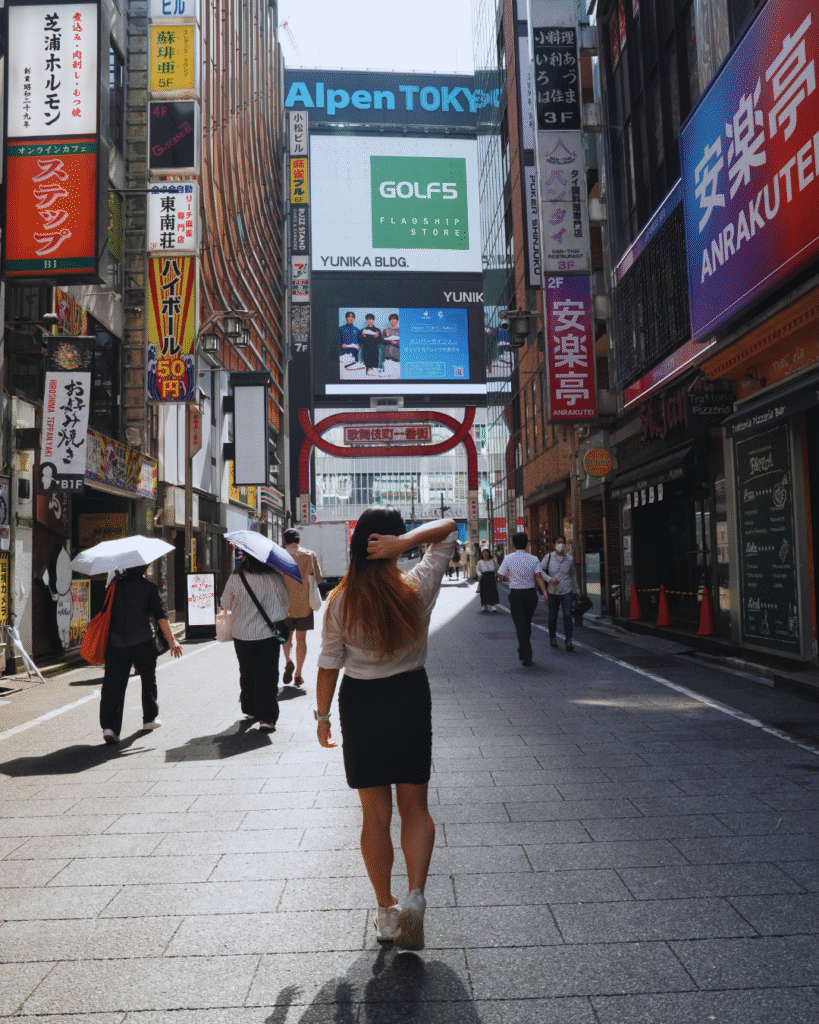 Flip Japan photo of a woman walking down the street in Shinjuku on day 1 of her 5 day Tokyo itinerary