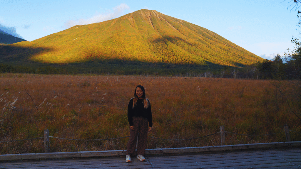 Flip Japan photo of a woman standing in front of a mountain in Senjogahara Marshland in Nikko