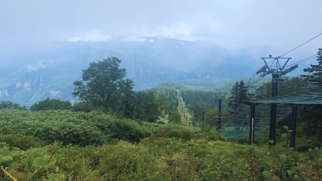 Photo of the view from the top of Daisetsuzan National Park with a chairlift in the foreground and mountains in the background