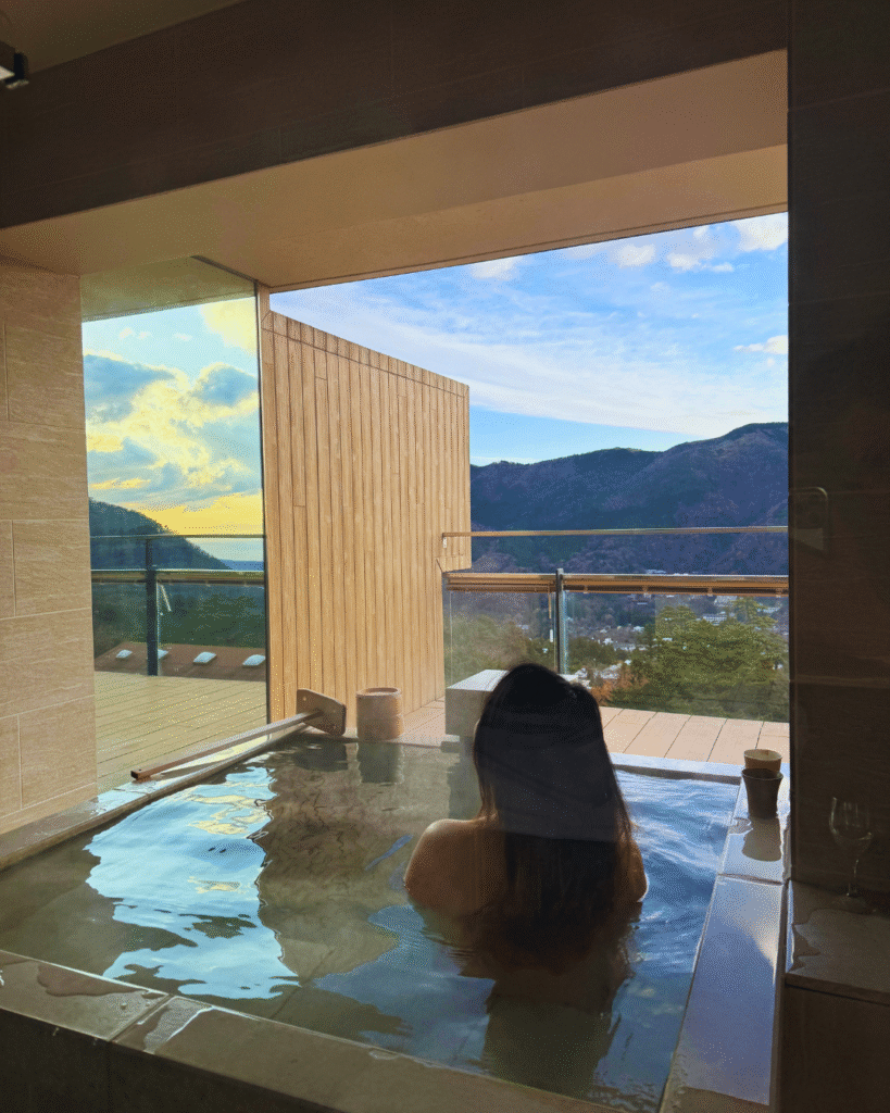 Flip Japan photo of a woman in an onsen overlooking Hakone during for Tokyo winter day trips