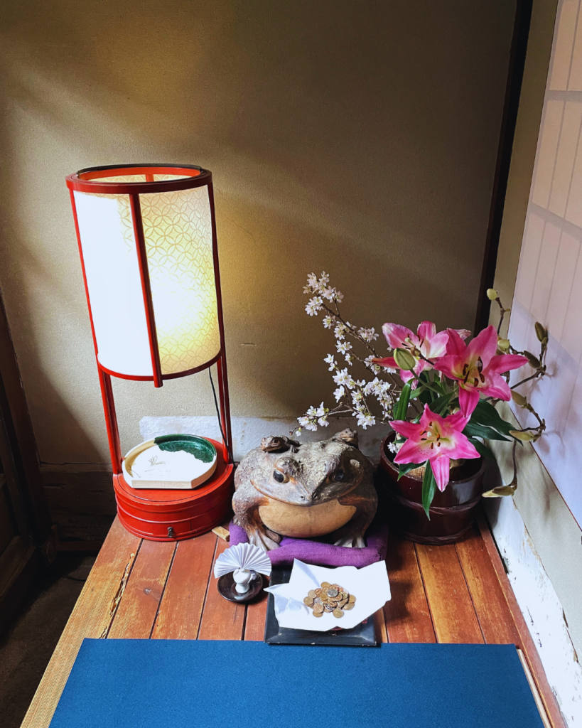 Flip Japan photo of a small shrine with flowers and a paper lantern