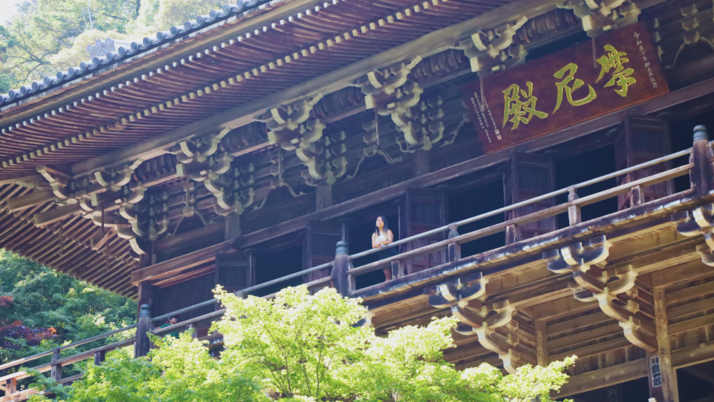 Flip Japan: Photo of a woman standing outside on the terrace of a wooden hall in Engyo Ji temple