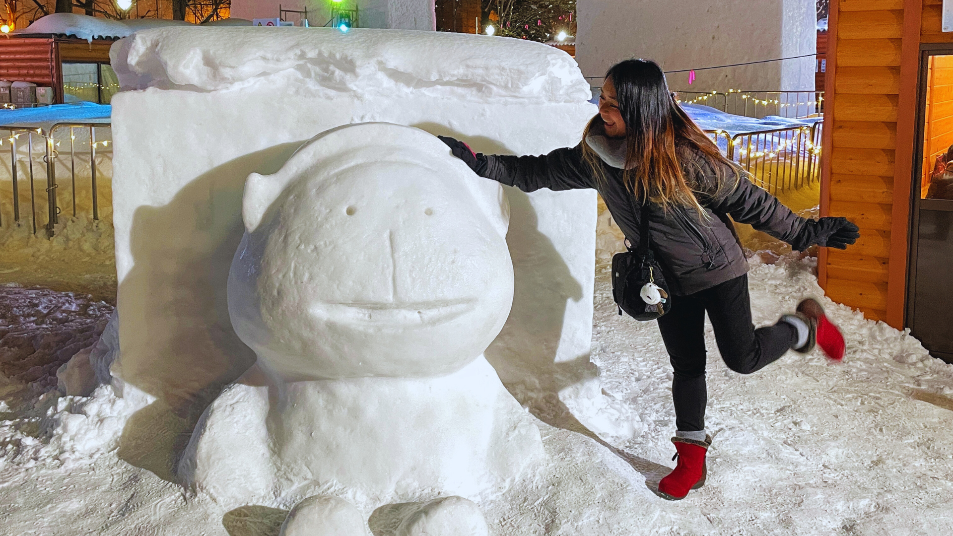 Flip Japan photo of Venese standing with a humansized snow sculpture of a character