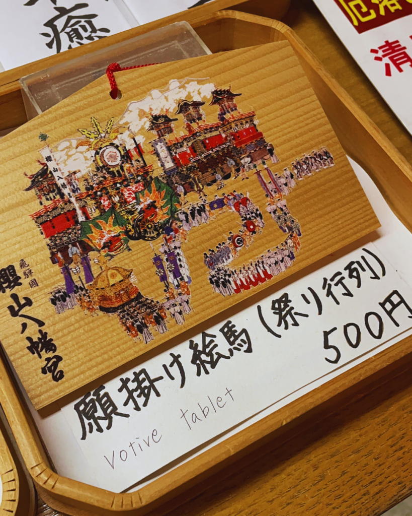 Flip Japan photo of a wooden votive tablet with a image of a Takayama Festiva float on it