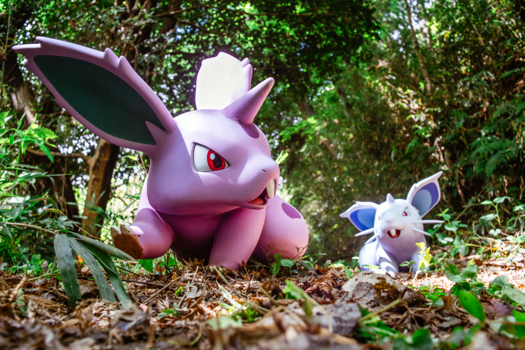 Photo of the Pokémon Forest in PokéPark Kanto with two nidoran pokémon running along the ground