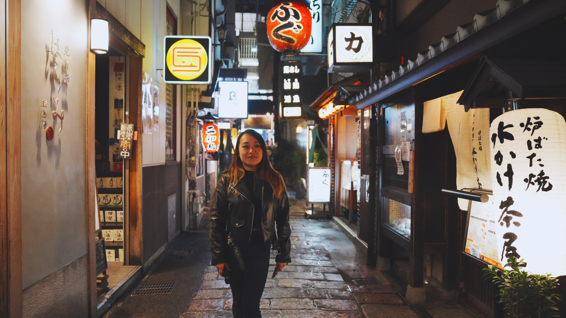 Flip Japan photo of Venese walking through a small street in Dotonbori at night with lots of neon signs