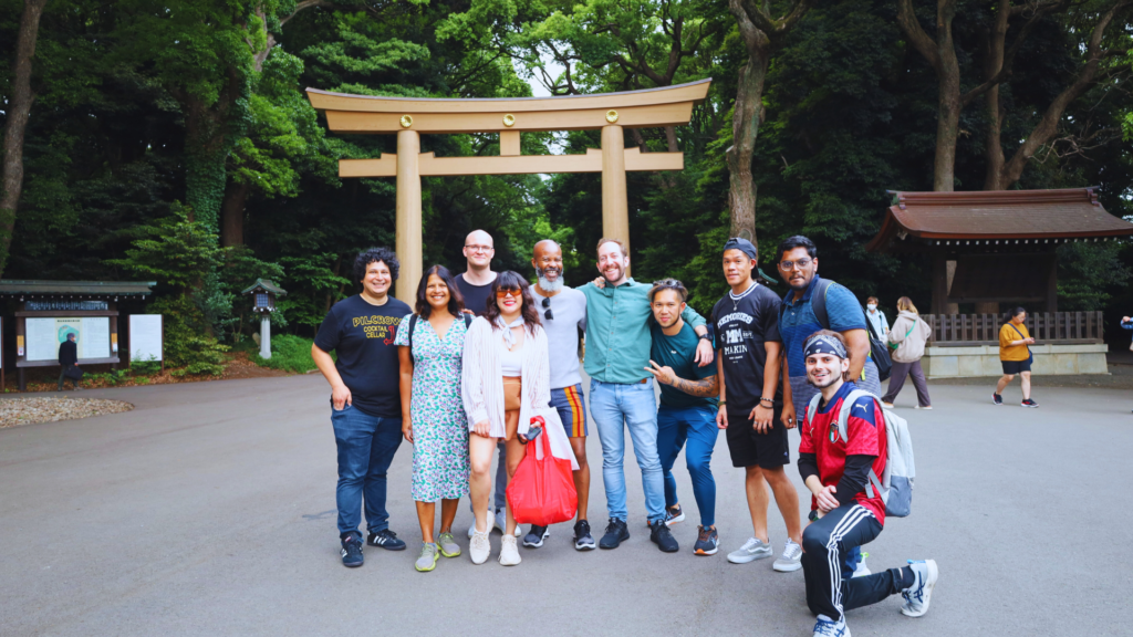 Flip Japan photo of a team on a group trip for  MICE Tourism in Japan standing under a torii gate in Meiji Jingumae Temple