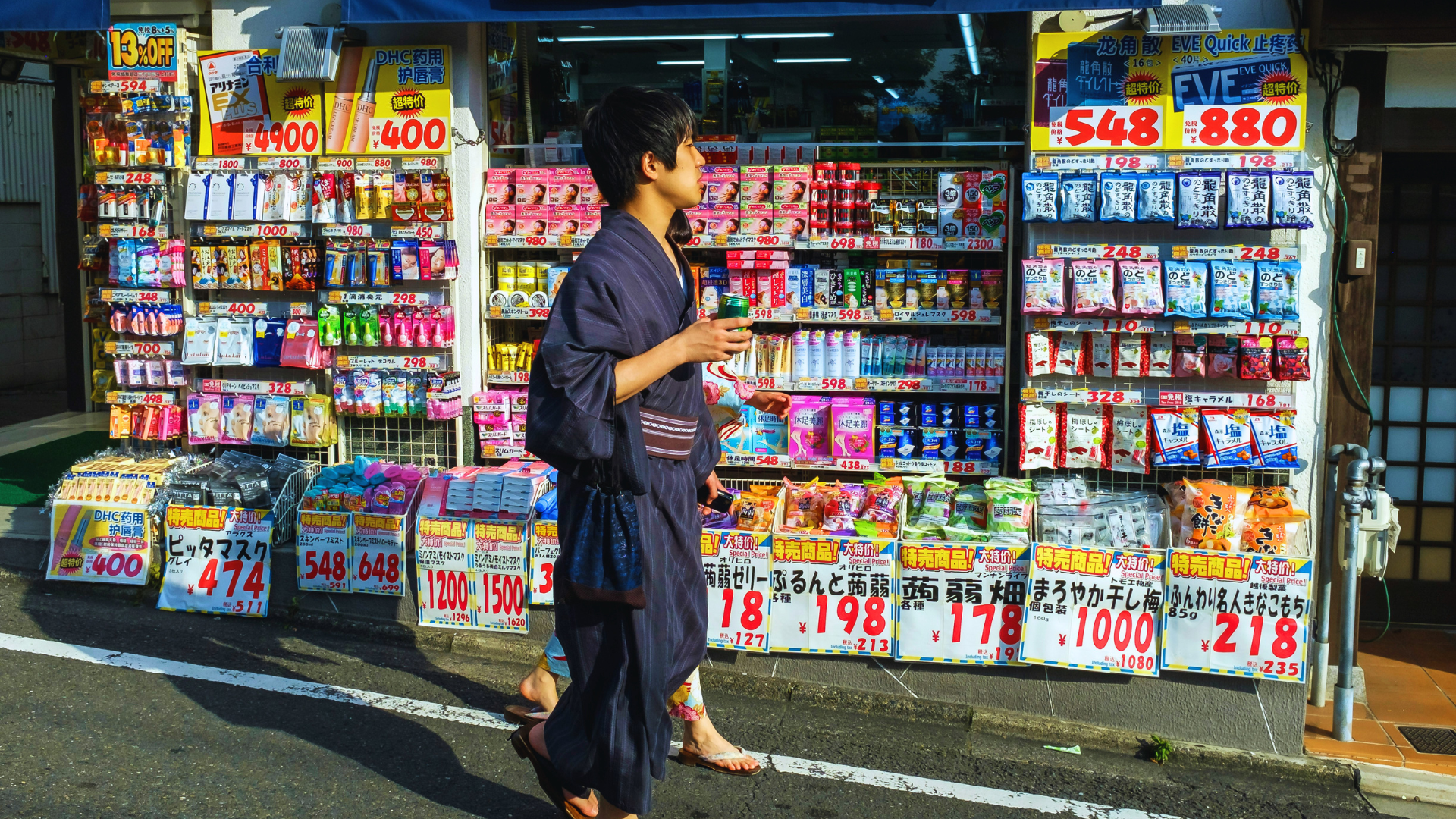 Flip Japan Guide to Japanese Beauty Products to Buy as Souvenirs: Drugstore Photo of a man in kimono walking past a drugstore filled with Japanese beauty products
