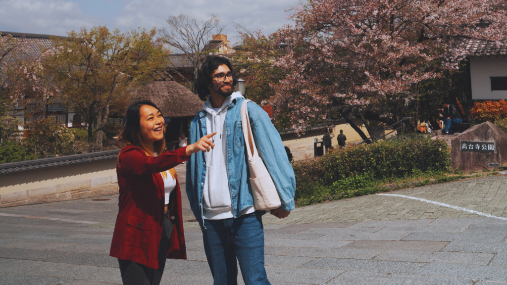 Flip Japan photo of a Japan media fixer showing a guest around Kyoto with cherry blossom in the background