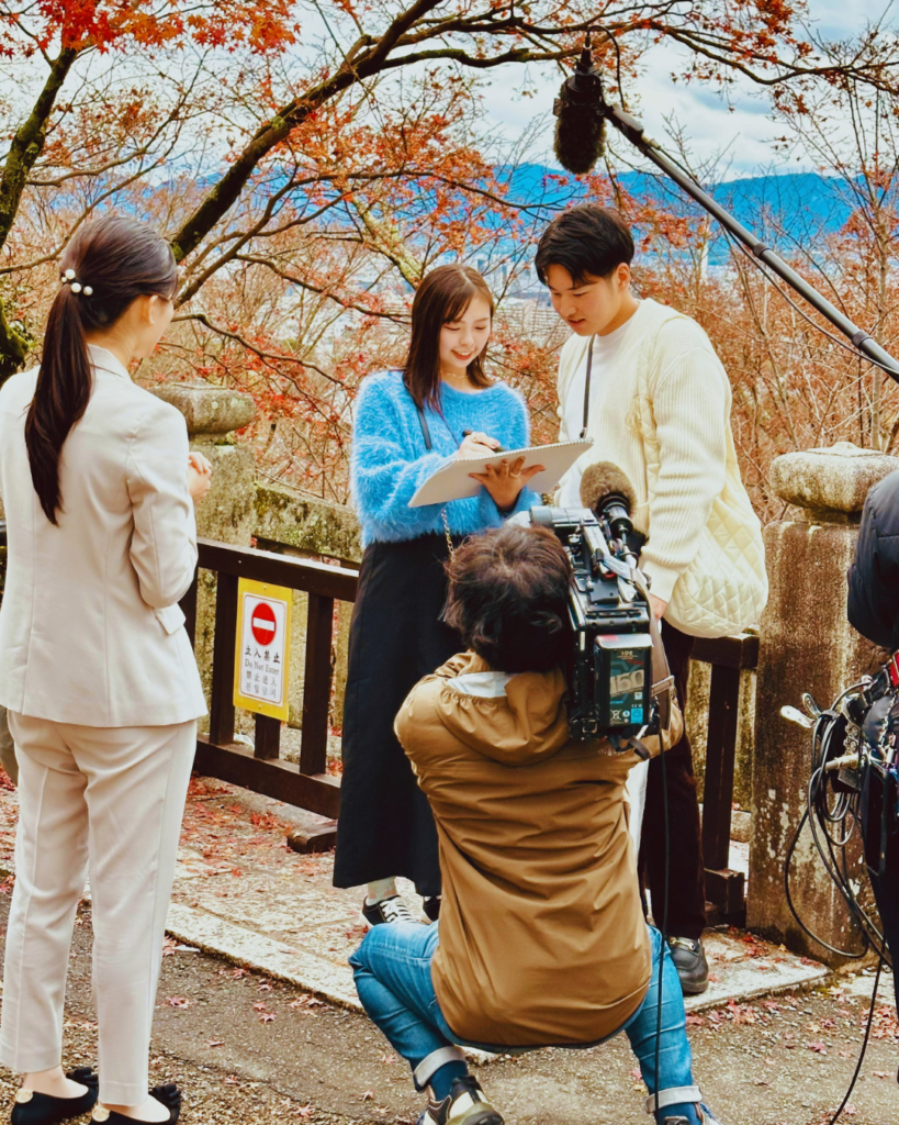 Photo of a film crew filming a woman interviewing a man filming in Japan