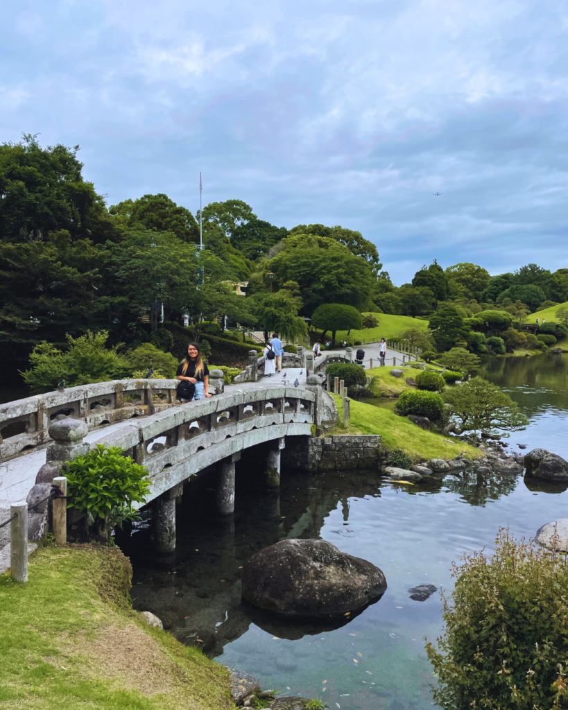 Flip Japan photo of Venese standing on a bridge in the traditional Japanese garden next to Kumamoto castle