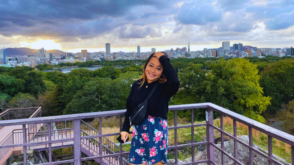 Flip Japan photo of Venese standin at the lookout point in Ohori Park with the Fukuoka skyline behind her