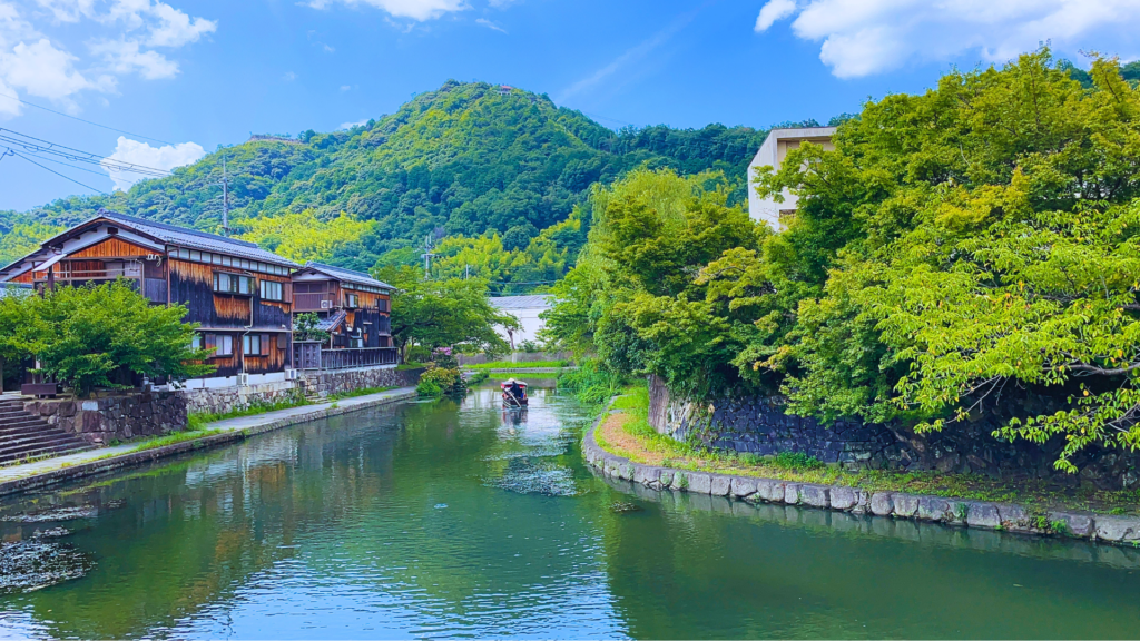 Flip Japan photo of Lake Biwa with a small traditional house on the left and mountains in the background