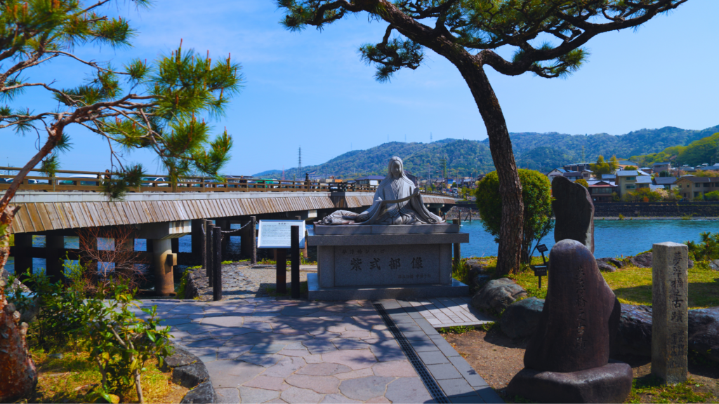 Flip Japan photo of the view of a river in Uji with a stone deity statue and a red bridge