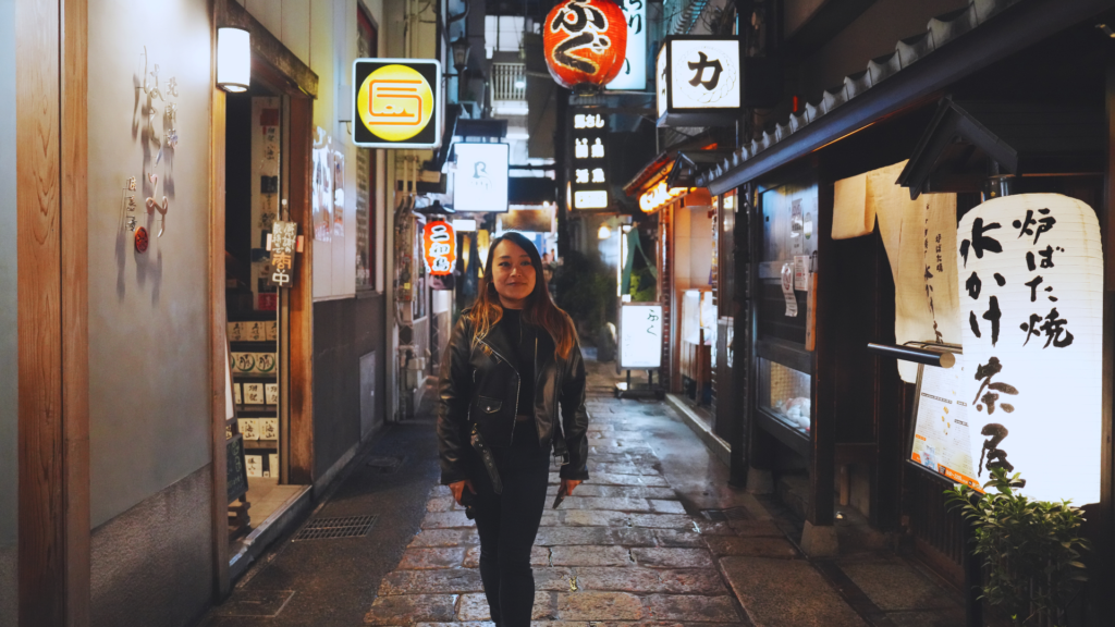 Flip Japan photo of Venese walking through the streets of Namba at night with neon signs around her