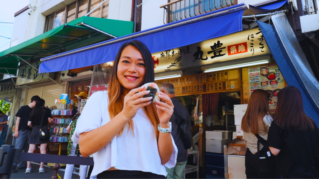 Flip Japan photo of Venese holding up an onigiri at a Tsukiji Market food tour in Tokyo