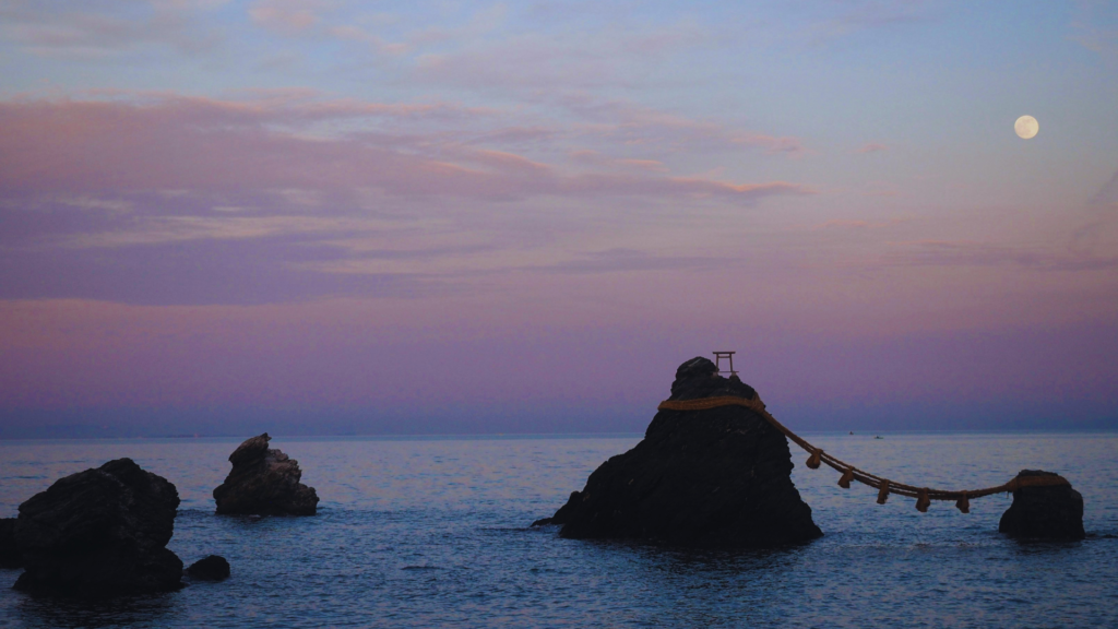 Photo of the full moon at sunset over a Japanese shrine in the ocean
