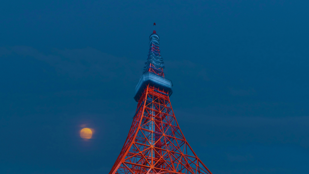 Photo of the full moon next to Tokyo Tower during Tsukimi