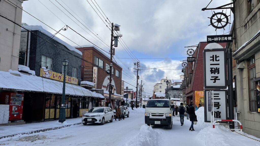 Snowy Sakaimachi Street in Otaru, with the sign for Kitaichi Glass’s No. 3 building on the right