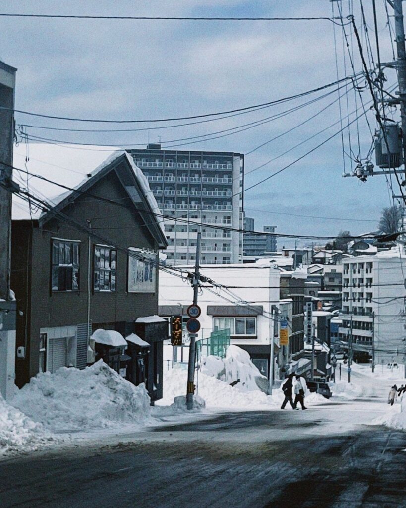 Snowbanks piled along a sloping residential street in Sapporo, Japan, in winter